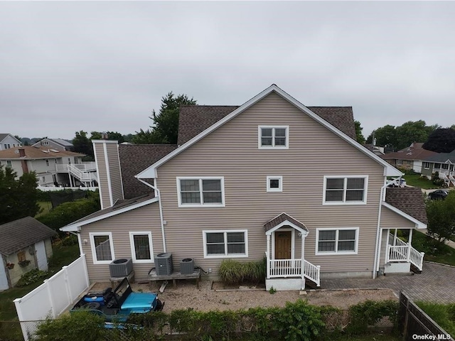 rear view of house featuring central AC unit