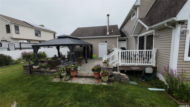 rear view of property featuring a gazebo, a patio, and a lawn