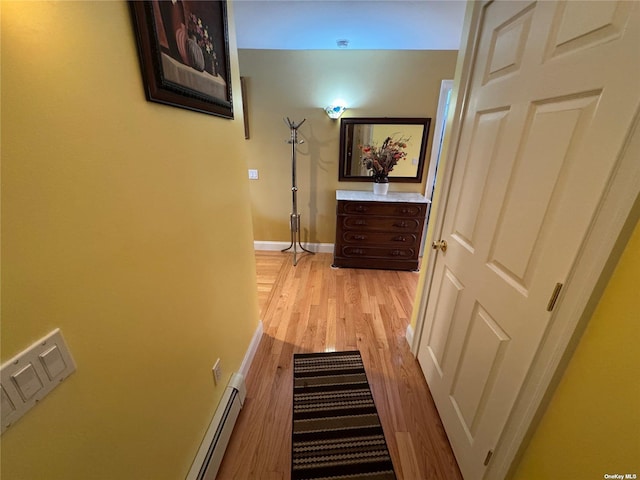 hallway with light hardwood / wood-style flooring and a baseboard heating unit