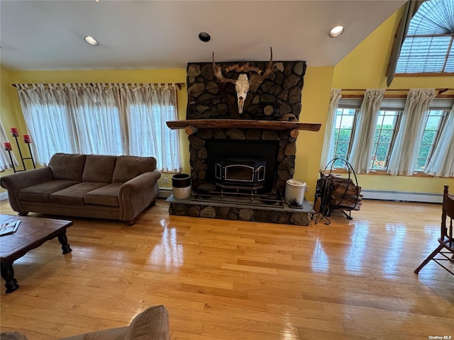 living room featuring vaulted ceiling, light hardwood / wood-style flooring, and a baseboard heating unit