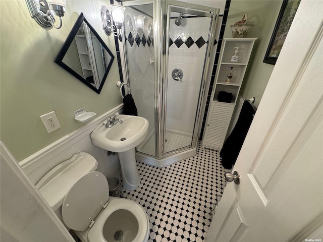 bathroom with a shower with shower door, tile patterned floors, and toilet