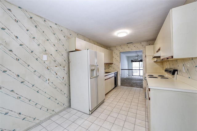 kitchen with white appliances, white cabinetry, and light tile patterned floors