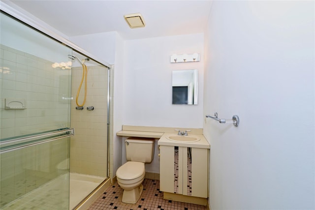 bathroom with tile patterned floors, vanity, toilet, and a shower with door