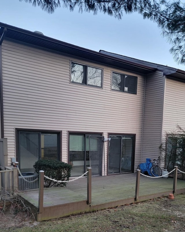 rear view of property with a deck and central AC unit