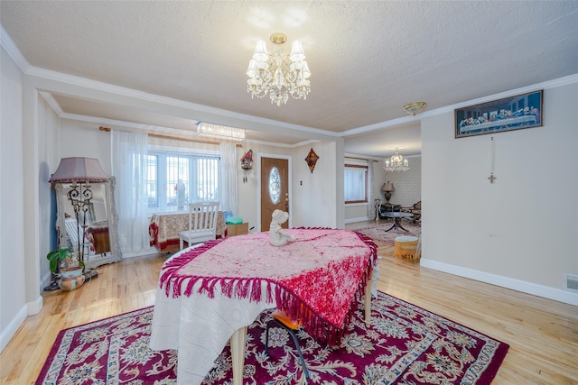 dining area with an inviting chandelier, hardwood / wood-style flooring, crown molding, and a textured ceiling