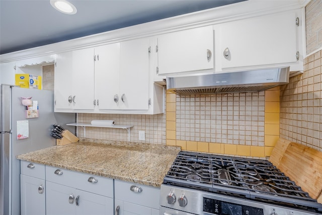 kitchen with white cabinetry, light stone counters, exhaust hood, and appliances with stainless steel finishes