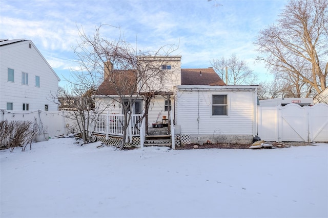 snow covered house with a deck