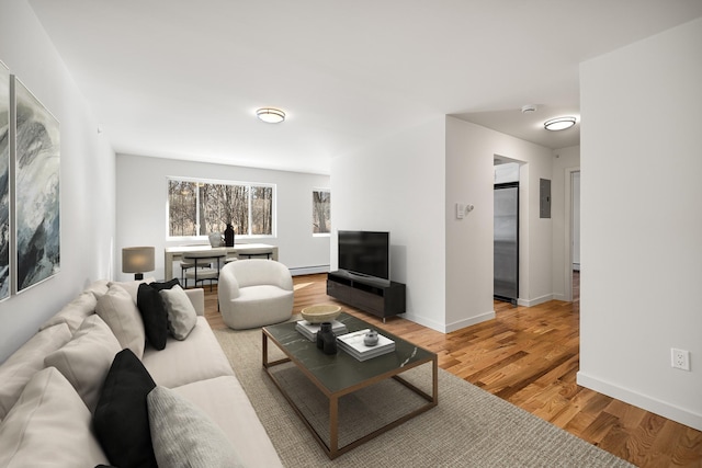 living room with baseboard heating, wood finished floors, and baseboards