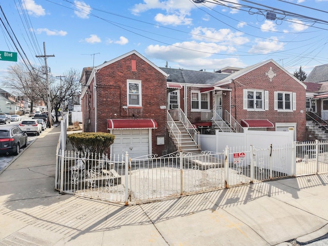 view of front of property featuring a garage, concrete driveway, brick siding, and a fenced front yard