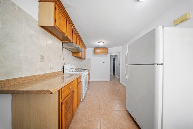 kitchen featuring light tile patterned floors, under cabinet range hood, white appliances, light countertops, and backsplash