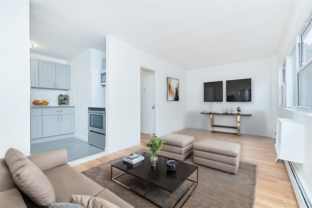 living room with light hardwood / wood-style flooring and a baseboard heating unit