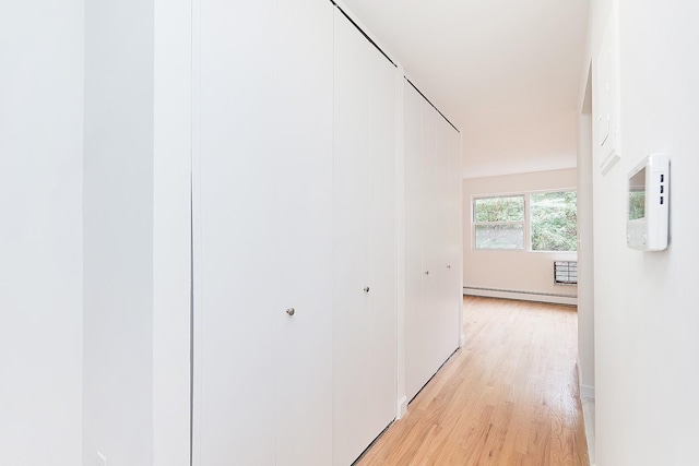 hallway with baseboard heating and light wood-type flooring