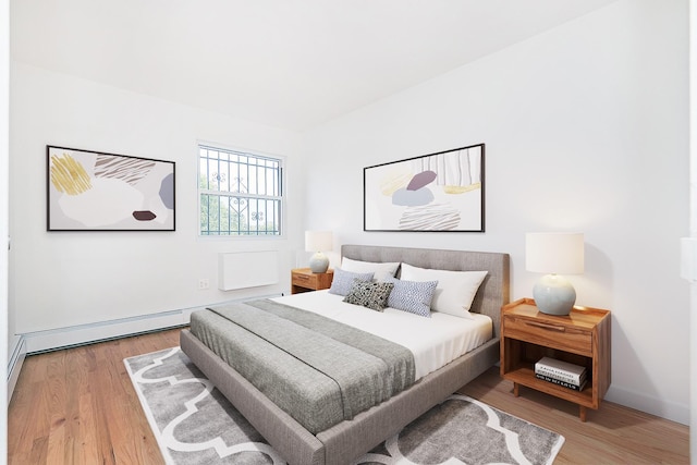 bedroom featuring baseboard heating and hardwood / wood-style floors