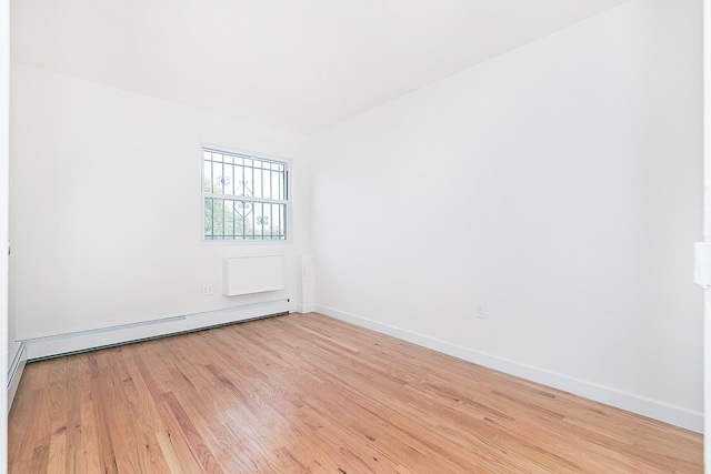 unfurnished room with light wood-type flooring and baseboard heating