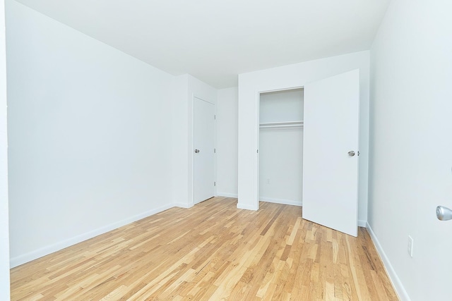 unfurnished bedroom featuring a closet and light wood-type flooring