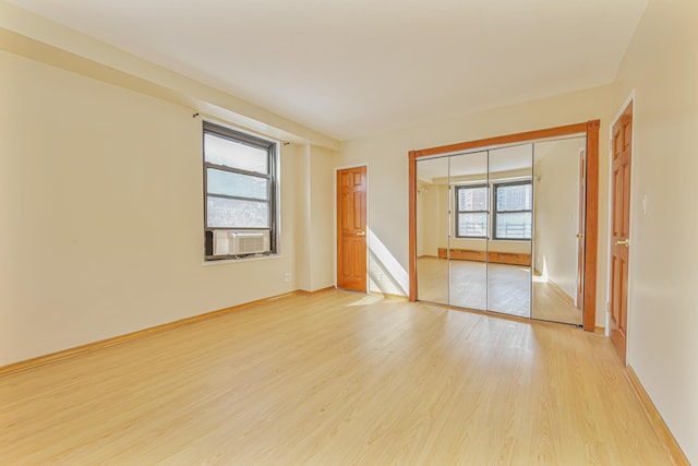 unfurnished room featuring cooling unit and light hardwood / wood-style floors