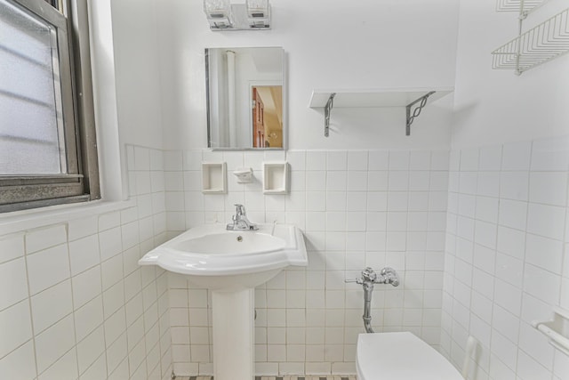 bathroom with toilet and tile walls