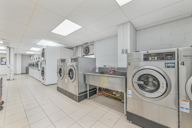 washroom with sink, light tile patterned floors, and washer and clothes dryer