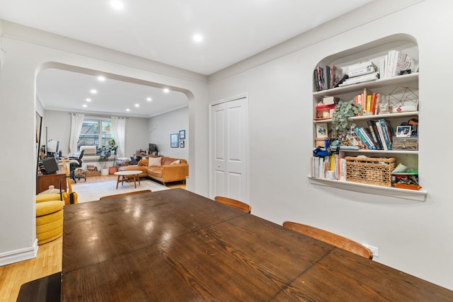 dining space with wood-type flooring and crown molding