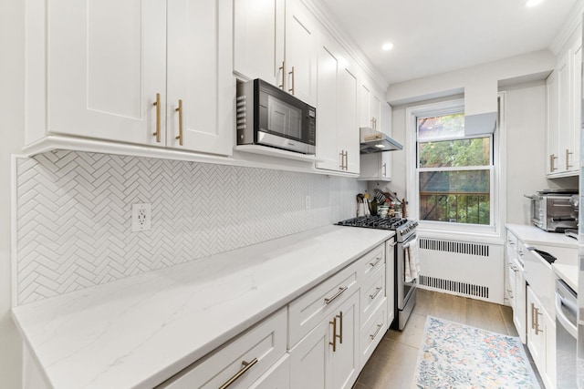 kitchen with white cabinetry, radiator, and stainless steel appliances