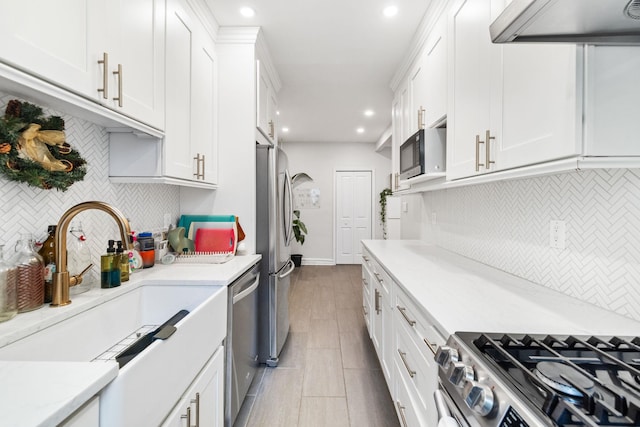 kitchen featuring sink, stainless steel appliances, exhaust hood, and white cabinets