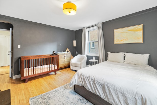 bedroom with crown molding and wood-type flooring