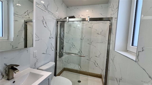 bathroom featuring vanity, a shower with shower door, and toilet