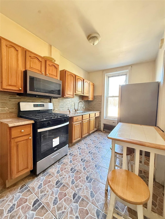 kitchen featuring appliances with stainless steel finishes, sink, and backsplash