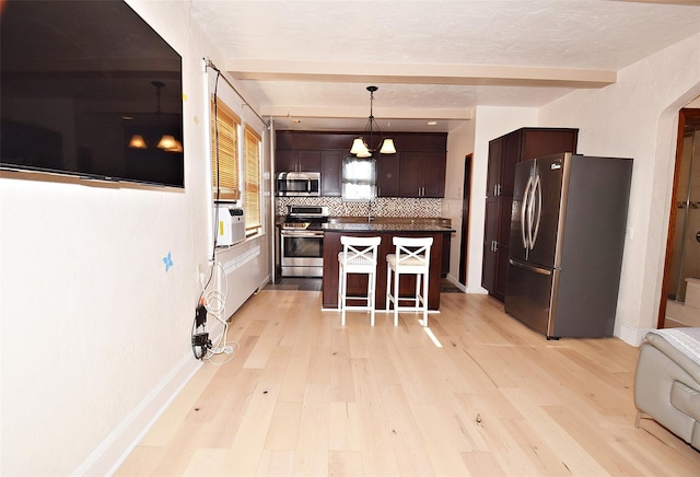 kitchen with stainless steel appliances, a center island, a kitchen breakfast bar, and beamed ceiling