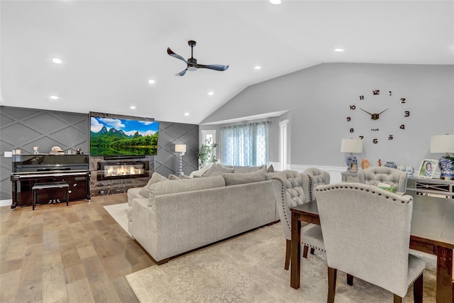 living room featuring vaulted ceiling, ceiling fan, and light wood-type flooring