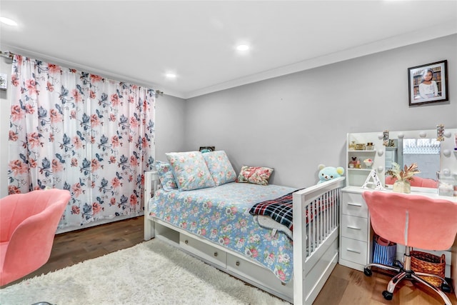 bedroom with ornamental molding and dark hardwood / wood-style floors