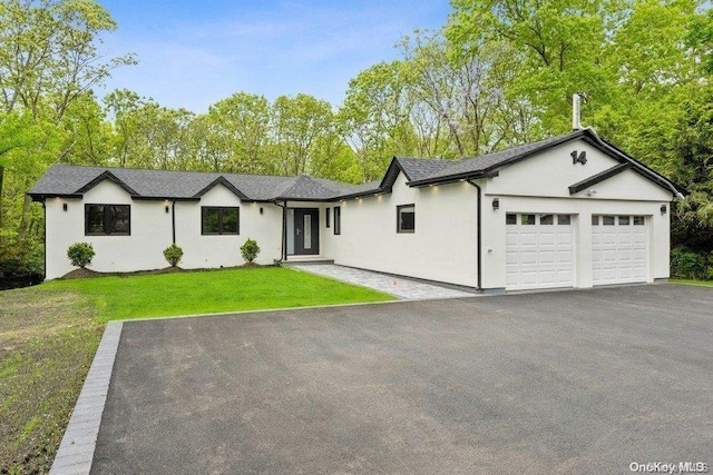 single story home with a garage and a front lawn