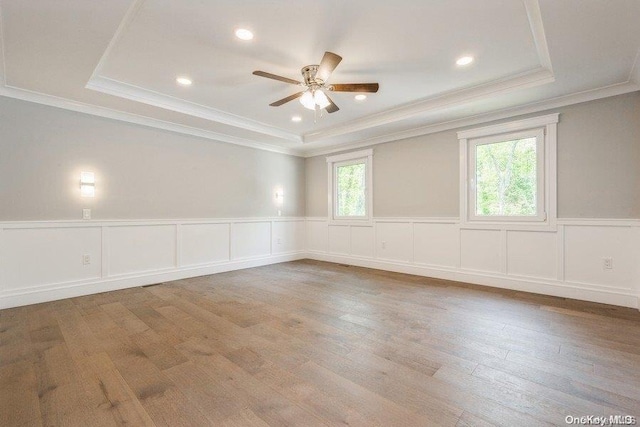 spare room with crown molding, hardwood / wood-style flooring, a raised ceiling, and ceiling fan