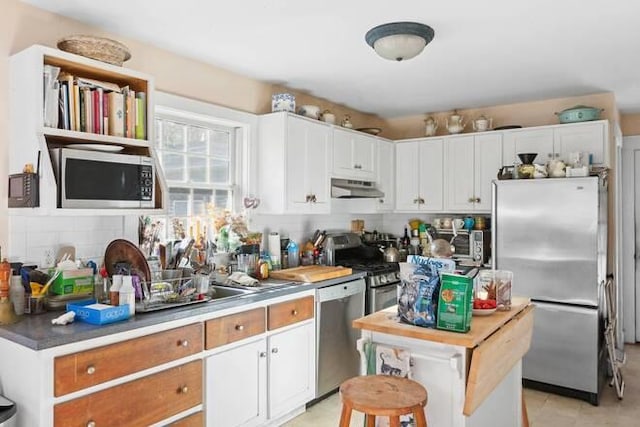 kitchen with stainless steel appliances, tasteful backsplash, and white cabinets