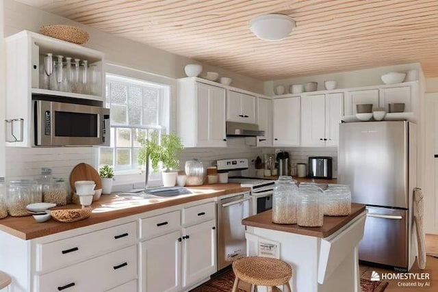 kitchen with sink, wood ceiling, white cabinetry, stainless steel appliances, and a center island