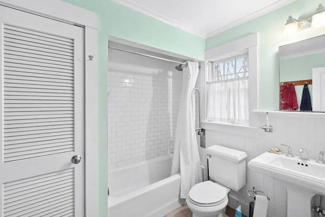 full bathroom with crown molding, shower / tub combo with curtain, toilet, and sink