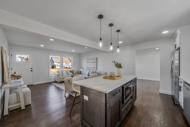 kitchen with dark hardwood / wood-style floors, white cabinets, hanging light fixtures, stainless steel appliances, and dark brown cabinets