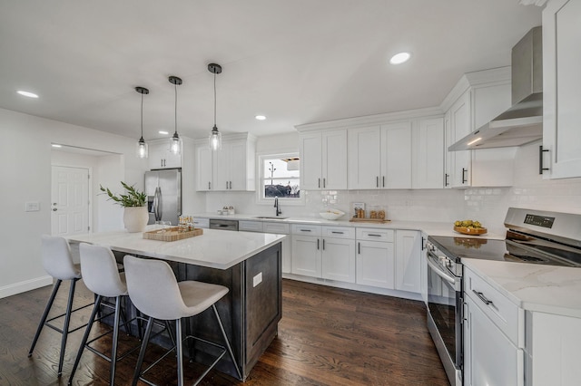 kitchen featuring white cabinetry, pendant lighting, stainless steel appliances, and wall chimney exhaust hood