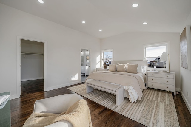 bedroom with lofted ceiling, ensuite bath, a spacious closet, dark hardwood / wood-style floors, and a closet