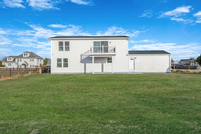 rear view of property with a yard and a balcony