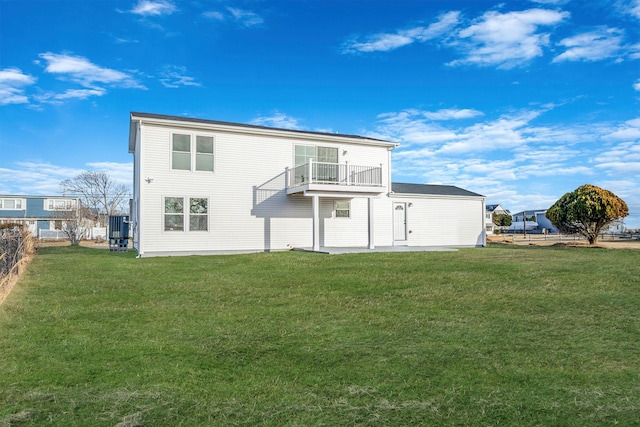 back of property with a balcony, central AC unit, and a lawn