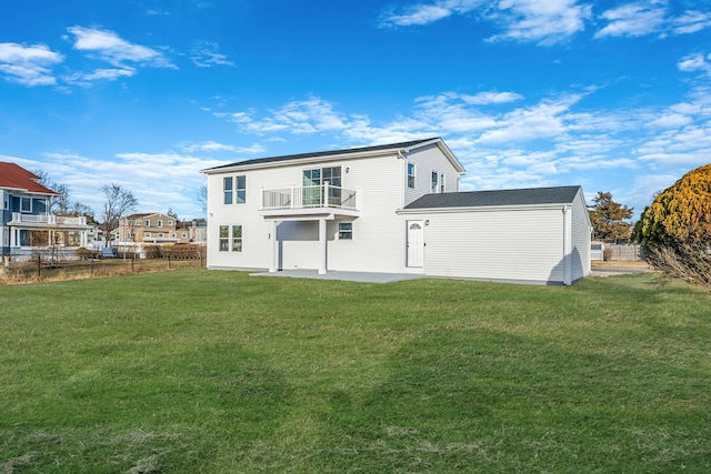 back of house featuring a balcony, a patio area, and a lawn