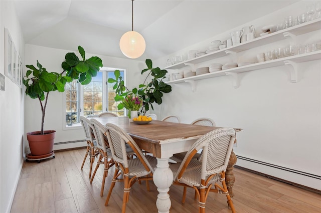 dining room featuring lofted ceiling, light wood-type flooring, and baseboard heating