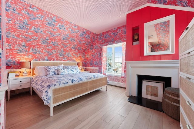 bedroom with wood-type flooring and vaulted ceiling