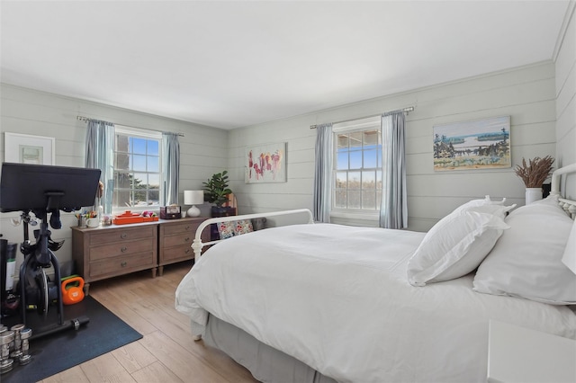 bedroom with light hardwood / wood-style floors and multiple windows