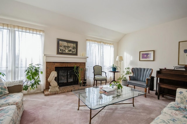 living room featuring lofted ceiling, a fireplace, and light colored carpet