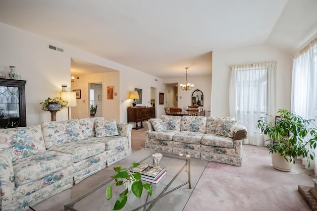 living room with visible vents, vaulted ceiling, light carpet, and an inviting chandelier