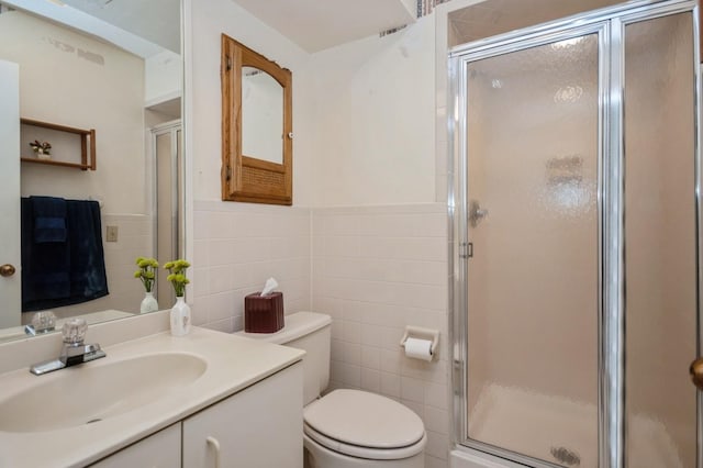 full bath featuring a wainscoted wall, tile walls, toilet, a stall shower, and vanity