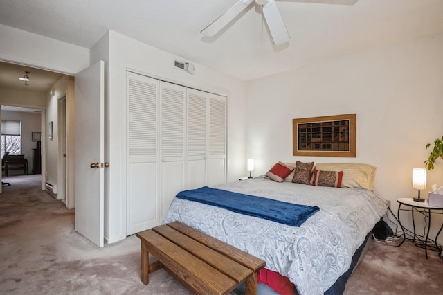 carpeted bedroom featuring ceiling fan, a closet, a baseboard radiator, and visible vents