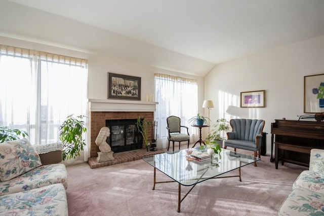 living area with lofted ceiling, a brick fireplace, and light carpet